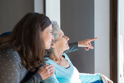 Mother and daughter looking out a window